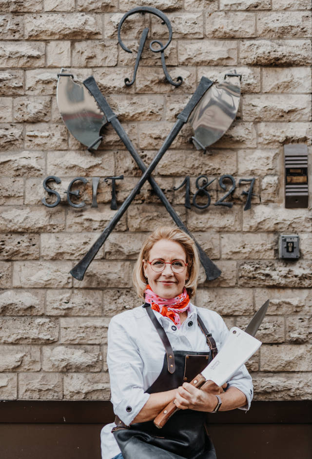 Susi vor dem Wappen vom Röber-Gourmetmarkt in Wolfenbüttel
